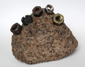 Mother stone, Berlin, 2023, field stone, screw nuts from collection, 14 x 10 x 6 cm